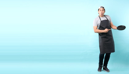 Dining concept. Asian man waiter holding an empty plate.isolated on blue background in studio With copy space.