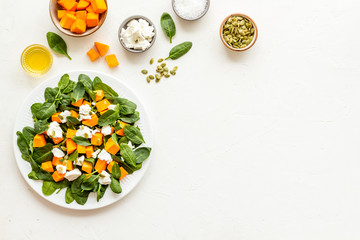 Cooking salad with pumpkin and basil. Ingredients on white background top-down copy space