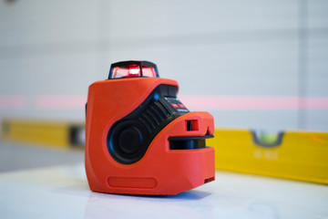 Laser level, used in apartment renovation. Optical instrument for accurate horizon level.