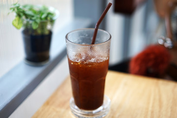 Close up glass of iced black Americano coffee on wooden table