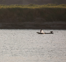 silhouette fisherman boat on mekong river