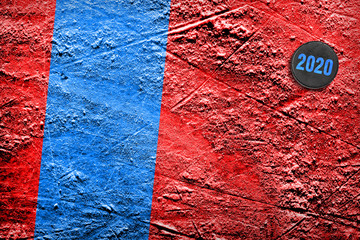 Hockey puck on red ice with a blue line