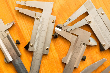 Vernier calipers on a wooden surface. High precision metalworking measuring tool