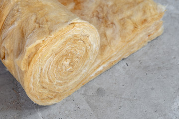 Mineral rockwool lying on attic floor inside house under construction