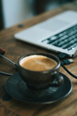 cup of coffee and laptop on table