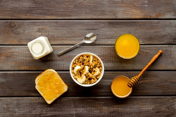 Granola for healthy breakfast. Still life composition with fruits and toast on wooden background top-down