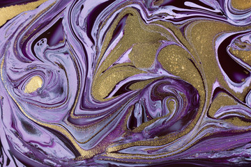 Mixed purple inks background with golden glitter. Abstract paint texture.