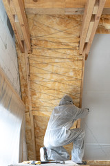 Foreman in overalls working with rockwool insulation material