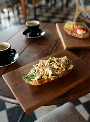 Closeup of single piece of italian bruschetta with cheese pasta toppings served with coffee in cafe