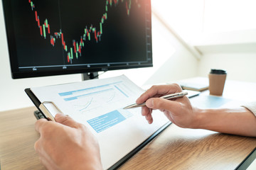 Businessman broker Analyzing finance data graphs and reports on screen for investment purposes for...