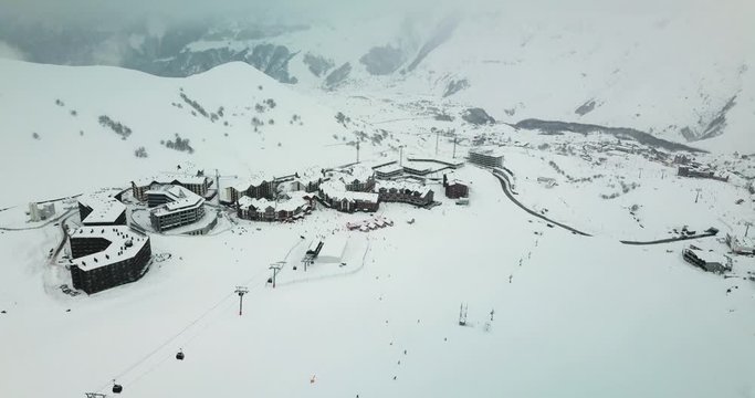 Aerial view on snowy ski resort Gudauri. Snowfall. Gondola lift and new building constructions