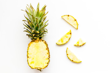 Pineapple - half of fruit and slices - on white background top-down