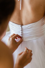 Hands Buttoning Back of Wedding Dress - 328228226