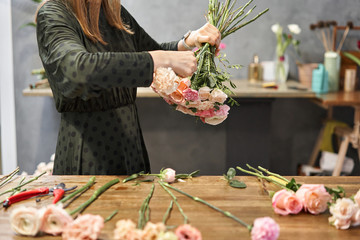 Woman florist creating beautiful bouquet in flower shop. Work in flower shop. Flowers delivery.