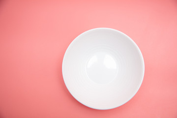 White plate isolated on pink background.