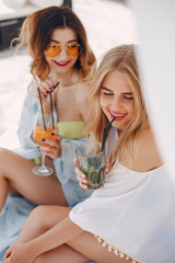 Girls near a pool. Friends in a stylish swimsuits. Ladies on a summer vacation