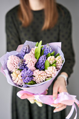 Young happy woman holding a beautiful bunch of colorful hyacinths in her hands. Present for a smiles girl. Flowers bouquet.