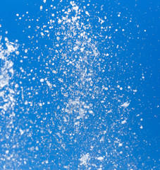 Splashing water from a fountain on a background of blue sky