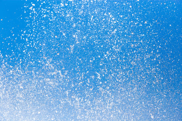 Splashing water from a fountain on a background of blue sky