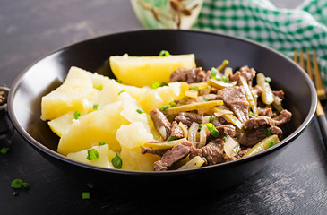 Stew beef, pieces of beef stewed with pickled cucumber in russian style. Beef stroganoff and boiled potatoes.