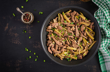 Stew beef, pieces of beef stewed in soy sauce with spices with pickled cucumber in asian style. Top view, overhead, flat lay