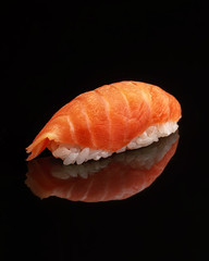 Traditional Japanese sushi on a black glossy background