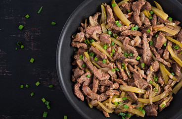 Stew beef, pieces of beef stewed in soy sauce with spices with pickled cucumber in asian style. Top view, overhead, flat lay
