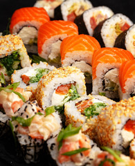 Traditional Japanese sushi food rolls on a black wooden background