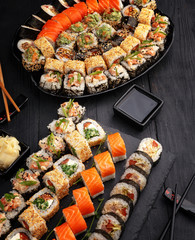 Traditional Japanese sushi food rolls on a black wooden background