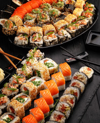 Traditional Japanese sushi food rolls on a black wooden background