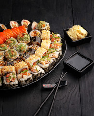 Traditional Japanese sushi food rolls on a black wooden background