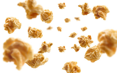 Caramel-flavored popcorn levitates on a white background