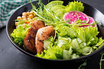 Trendy salad. Buddha bowl dish with chicken fillet, chickpea, cucumber, radish,  fresh lettuce salad, pea sprouts  and chia seeds. Healthy food.