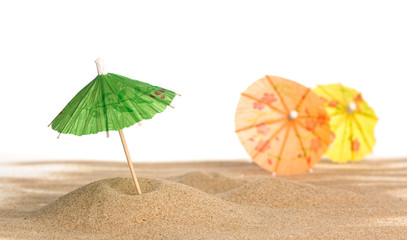 Cocktail Umbrella in Sand on white background