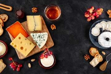 Cheese variety. Goat cheese, Brie, blue cheese etc, shot above on a dark background with copy space