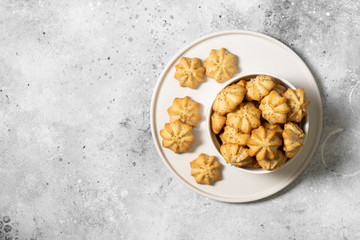 Lemon cookies with poppy seeds in a white ceramic bowl on the gray kitchen table. Shortbread. Space for text