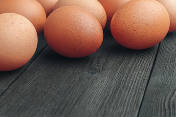 Closeup fresh brown chicken eggs on old vintage wooden boards with copy space