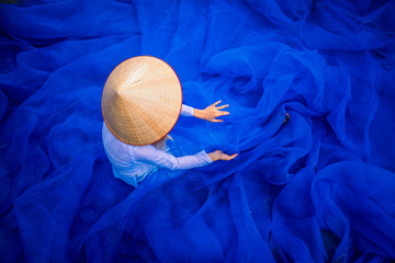 Vietnamese girls are cleaning fish trap mesh. fisherman pull fish net. Traditional and culture of...