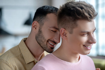 Close up picture of gay couple looking pleased