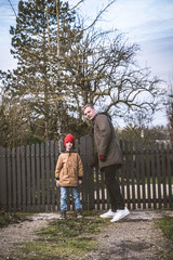 Fototapeta premium Father and son closing their wooden gate in a house in a cozy European city