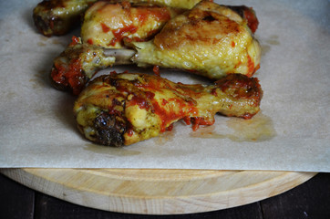 Grilled spicy chicken legs on a black background.Top view. backet chicken on paper