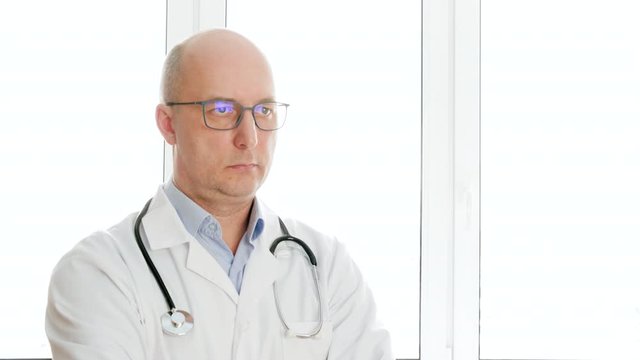 Portrait doctor in white medical gown with phonendoscope nodding head yes and no. Male medical worker with stethoscope with negatively positively shaking head. Practitioner in white coat in hospital