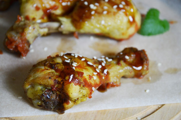 Grilled spicy chicken legs on a black background.Top view. backet chicken on paper