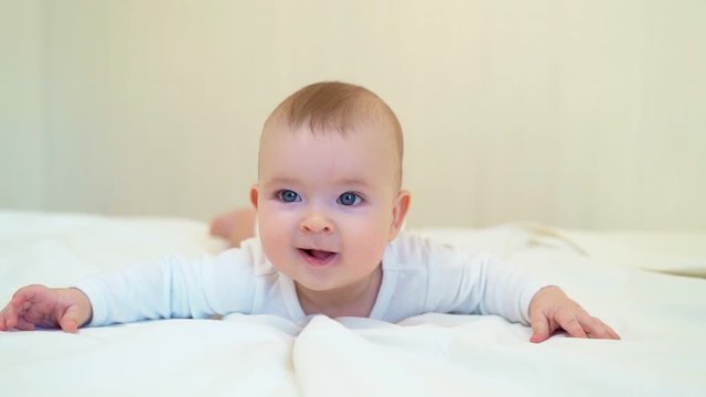 baby in white lying on paunch on white bed