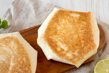 Crispy Homemade Beef Crunchwrap Quesadilla on a rustic wooden board, high angle view. Close-up.
