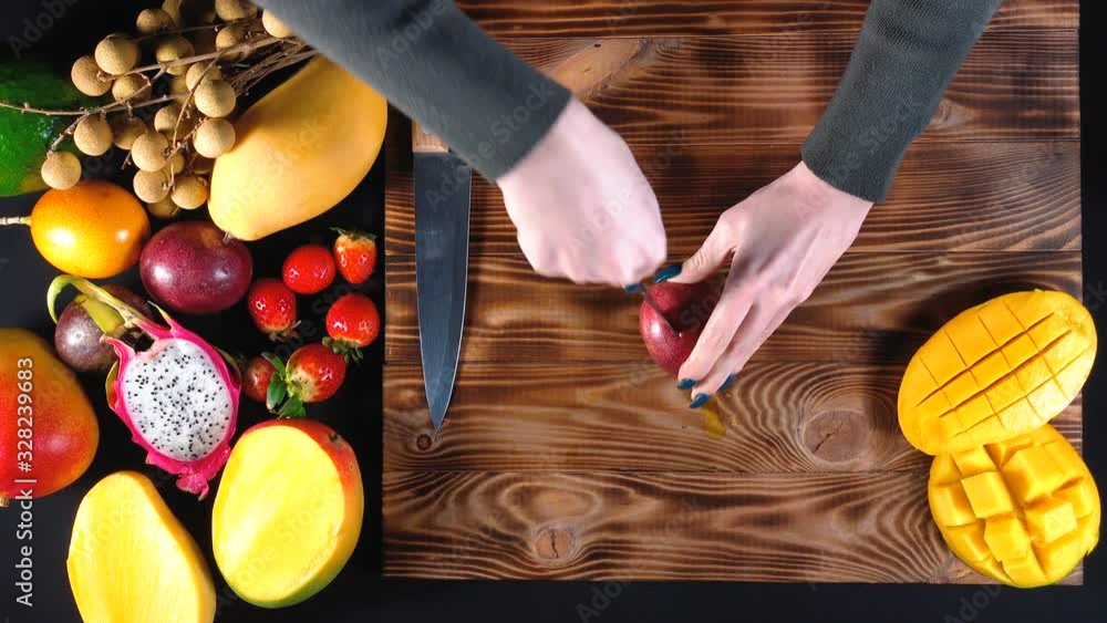 Wall mural video of woman cuts passion fruit, top view