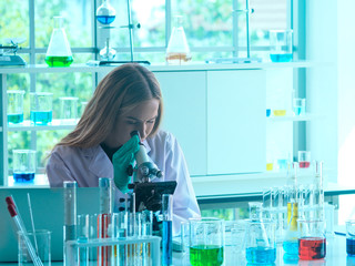 Female scientist using microscope to analyse the virus in the lab. Science, Medical, health, and...