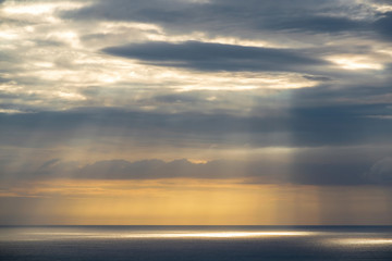 Naklejka na ściany i meble Long aerial view of gray evening clouds over Tasman sea coast at Piha with run rays