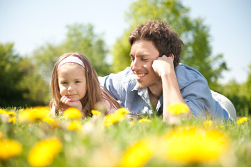 Happy family. Father with daughter on a meadow.