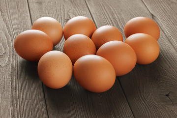 Fresh brown chicken eggs with shallow depth of field on the surface of an old wooden rustic table